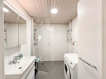 Tyylikäs kylpyhuone jossa mm. pesukoneliitäntä.