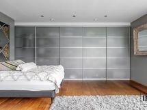 Sängyn takana viinihylly.