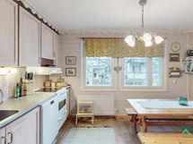 Valoisassa keittiössä kauniit käsitellyt paneelit seinissä.