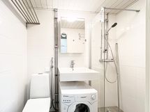 Kylpyhuoneessa on valmiina pyykinpesukone.