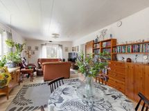 Valoisa ja tilava olohuone josta näkymä metsään