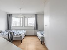 Makuuhuone on levollinen ja tulvii luonnonvaloa suurista ikkunoista.