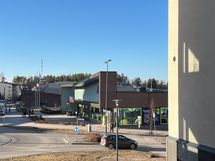 Lähikauppa on tien toisella puolella. Samassa rakennuksessa on pitseria ja parturi-kampaamo.