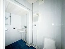 Laatoitetussa kylpyhuoneessa on paikka ja liitäntä pyykinpesukoneelle.