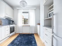 Erillinen keittiö on siistissä kunnossa ja siellä on runsaasti kaappi- sekä laskutilaa.