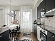 ... ja vastapainona tumma keittiö tuo tilaan särmää.