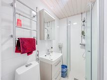 Kylpyhuone on kokonaan laatoitettu ja siellä on paikka pesukoneelle.