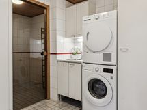 Kodinhoitotila ja lasiovi kylpyhuoneeseen