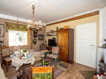 Tunnelmallinen olohuone, ovi johtaa makuuhuoneeseen.