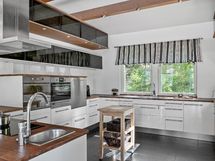 Moderni iso keittiö monipuolisine laitteineen kutsuu kokkaamaan