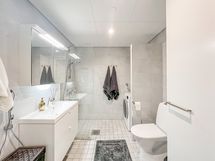 Kylpyhuoneessa pesukone valmiina.