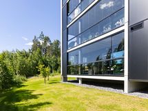Upea lasitettu parveke vehreässä talon kulmauksessa