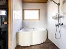 Saunatilan suihku ja poreamme, valaistuksena katossa kuituvalot