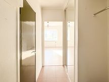 Eteisessä naulakko ja liukuovikaapistoa.