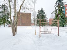 Pihalla on lasten leikkitelineitä ja mattoteline.