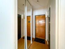 Eteisessä naulakko ja peililiukuovikaapistoa.