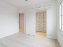 Valokuva asunnosta B 32 - makuuhuone 1, jonka yhteydessä on vaatehuone.