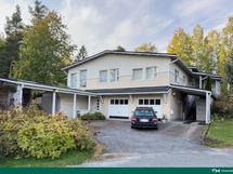 Julkisivu kadultapäin. Edessä autokatos, myytävän huoneiston autotalli vasemmalla puolella