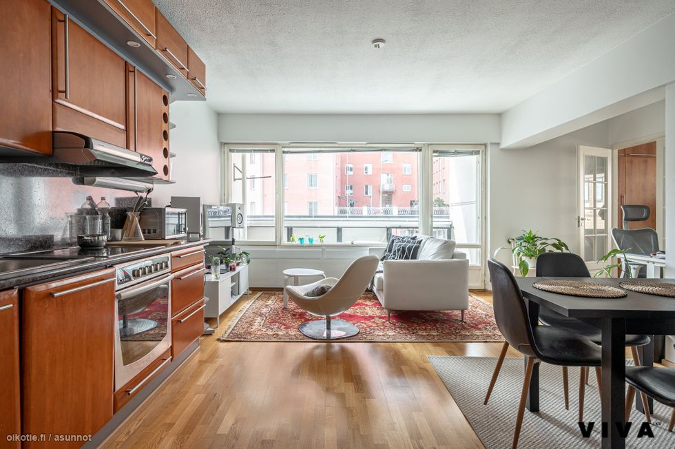 Avara olohuone ja keittiö – kaupunkikodin sydän, jossa valoa ja tilaa riittää.