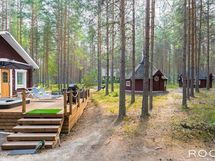 Kaunis luonnonmukainen pihapiiri. Kuvassa huvilan terassia, pihasauna ja huvimaja
