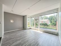 Olohuoneessa upeat isot ikkunat pihalle.