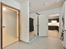 Oikealla pesutoni ja vastapäätä liukuovikaapistot.