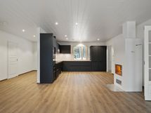 Vaaleaan kotiin tumma keittiö integroituine kodinkoneineen tuo kivasti vastakohtaa.