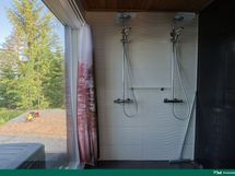 Suihkutilassa valtaisa ikkuna järvelle - verholla voi halutessaan peittää näkyvyyttä