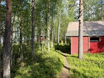 Varastorakennus, taustalla mökki