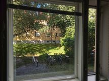 Makuuhuoneen ikkuna avautuu rauhallisen ja vehreän sisäpihan suuntaan.