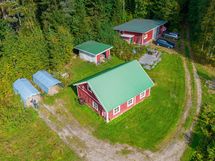 Etualalla karjasuoja, pressutallit, puuvaja ja autotalli.