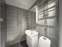 Tyylikäs kylpyhuone on uusittu putkiremontin yhteydessä. Pesukoneelle on paikkansa.