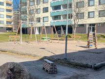 Taloyhtiön pihalla on lasten leikkitelineitä ja istuinryhmiä.