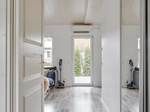 Terassin kokolasinen ovi tuo luonnon lähelle ja valoa huoneistoon.