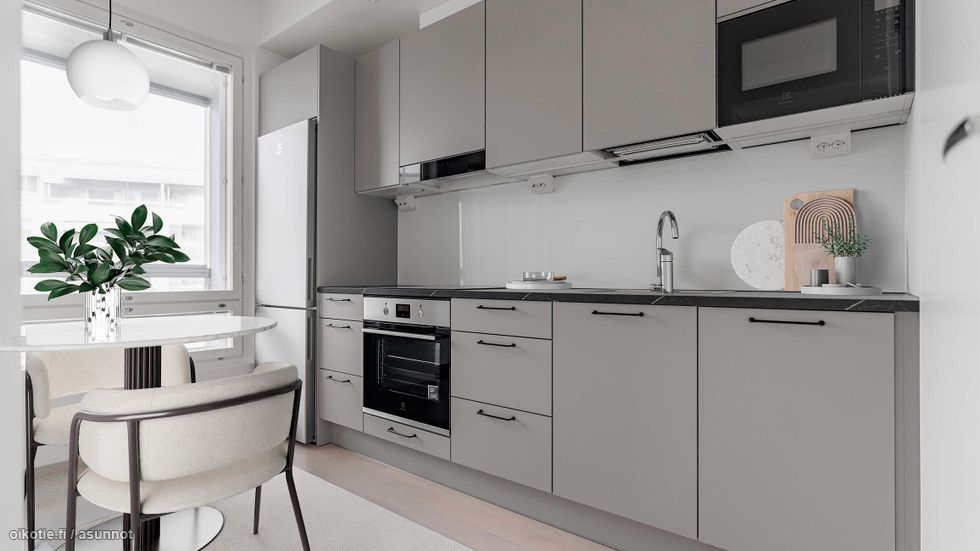 Digistailattu asunto A 23 - Tyylikäs harmaan sävyinen Puustellin keittiö, jossa tummat työtasot ja integroidut kodinkoneet tuovat modernia ilmettä.