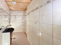 Kylpyhuone on laatoitettu ja tilava.