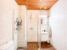 Kylpyhuone on siisti ja laatoitettu.