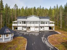 Ilmakuva julkisivusta, nykyään oikeassa laidassa pihaa sähköautonlatauspaikka sekä B-asunnon paikka