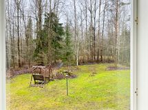 Huoneen ikkuna katselee talon takapihalle, lännen suuntaan. Ikkunassa on pimennysrullaverho.