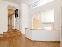 Sisääntulo kirjastoon, ikkunat viettävät lasiverannalle.