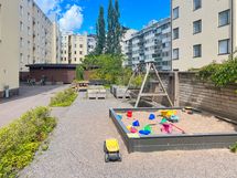 Sisäpihalla leikkipaikka ja oleskelualue sekä taustalla näkyy pyörävarasto.