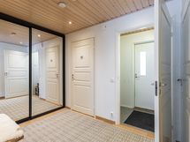 Näkymä eteisestä tuulikaapin suuntaan, jonka vasemmalla on wc ja oikealta kulku kodinhoitohuoneeseen