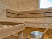 Saunassa kivipilarikiuas ja ikkuna.