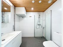 Tilavassa kylpyhuoneessa on sopivasti säilytystilaa ja paikka pyykinpesukoneelle.