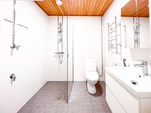 Tilava laatoitettu kylpyhuone hyvällä suihkutilalla sekä pesukoneliitännällä.