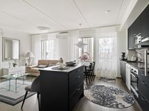 Viihtyisää, yhteistä seurustelu- ja oleskelutilaa avokeittiön avautuessa olohuoneeseen.