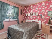 Yläkerran makuuhuone. Ikkunasta avautuu rauhoittava metsämaisema