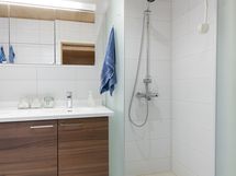Suihku ja kaapistot kylpyhuonessa, joka on remontoitu v. 2016