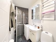 Tyylikkäässä kylpyhuoneessa on paikka päältä täytettävälle pyykinpesukoneelle.