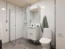 Tilava, moderni kylpyhuone, johon mahtuu pesutorni.